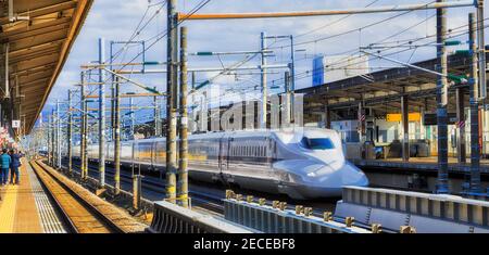 Weite Ansicht des Schnellzuges, der Bahnhofsplattformen in Shin-Fuji Stadt von Japan an einem sonnigen Tag durchfährt. Stockfoto