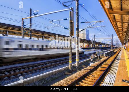 Verschwommener Hochgeschwindigkeitszug, der durch den Bahnhof Shin-Fuji mit einer Geschossgeschwindigkeit fährt - verschwommen. Stockfoto