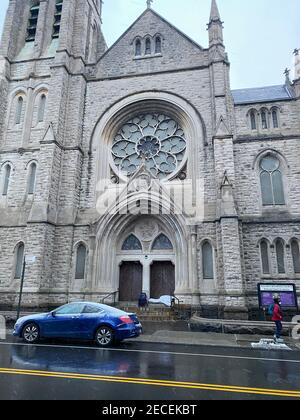 Regnerischer Morgen mit einem Mann, der an der Tür einer Kirche auf der 7th Avenue im Park Slope Viertel von Brooklyn, New York, schläft. Stockfoto