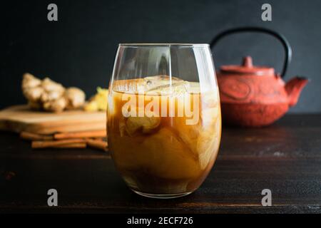 Kardamom Zimt Kurkuma Iced Tea: Eistee mit Kardamom infundiert und mit Kurkuma-Zimt Kokosmilch verwirbelt Stockfoto