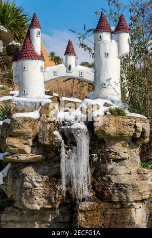 Never Never Landen Fairy Castle mit gefrorenen Eiszapfen in Southend on Sea, Essex, Großbritannien, mit Schnee von Storm Darcy. Gefrorener Wasserfall aus Modell Fee Burg Stockfoto