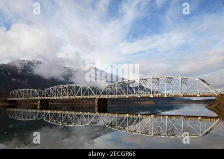 Die historische Noxon-Stahltrassebrücke, die 1922 erbaut wurde, überspannt den Clark Fork River bei Sonnenaufgang, als ein Sturm sich licht, Montana. (Foto von Randy Beacham) Stockfoto