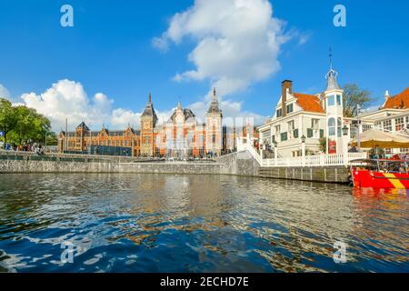 Blick auf den Kanal von Amsterdam Centraal, dem größten Bahnhof von Amsterdam, Niederlande, und einem großen Bahnknotenpunkt Stockfoto