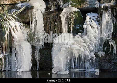 Nahaufnahme von großen gefrorenen Eiszapfen, die im Winter am Wasserfall hängen Stockfoto