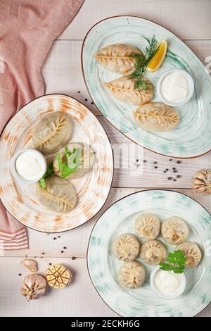 Georgische hausgemachte Speisen namens Khinkali und Manti auf den Tellern Stockfoto
