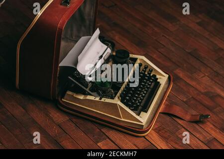 Vintage Schreibmaschine mit weißem Papier steht auf dem Boden drinnen Stockfoto