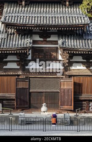 Buddhistischer Abt Mönch, der vor der goldenen Halle (Kondo) des Toji Tempels, Kyoto, Japan betet Stockfoto