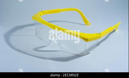 Eine medizinische Gesichtsmaske mit Schutzbrille auf weißem Hintergrund, isoliert, Konzept Epidemie Coronavirus Stockfoto