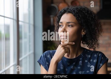 Nahaufnahme nachdenkliche afroamerikanische Frau, die aus dem Fenster schaut Stockfoto