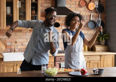 Nahaufnahme überglücklich afroamerikanischen Paar singen in Küchengeschirr Stockfoto