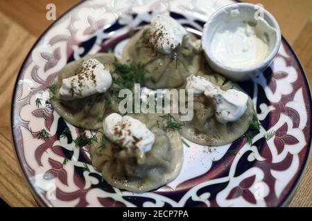 Tatar Manti mit Sauce auf dem Teller im Restaurant Stockfoto