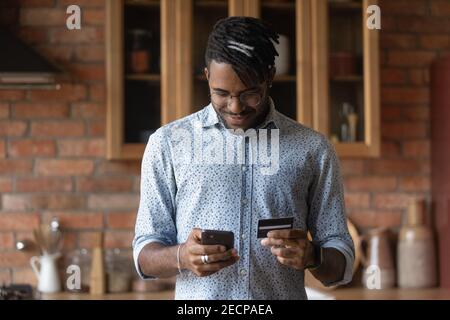 Nahaufnahme afroamerikanischer Mann mit Telefon und Karte, online bezahlen Stockfoto