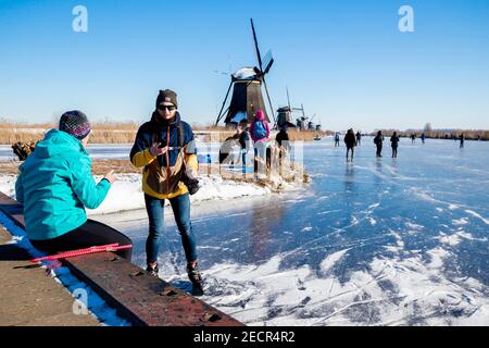 KINDERDIJK, NIEDERLANDE - FEBRUAR 13: Am 13. Februar 2021 wird man in Kinderdijk, Netherla das Winterwetter beim Schlittschuhlaufen auf Natureis beobachten Stockfoto