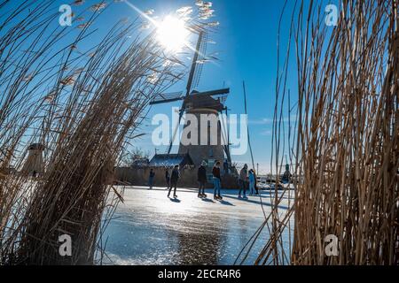 KINDERDIJK, NIEDERLANDE - FEBRUAR 13: Am 13. Februar 2021 wird man in Kinderdijk, Netherla das Winterwetter beim Schlittschuhlaufen auf Natureis beobachten Stockfoto