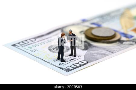 Geschäftsleute Miniatur Figur Makro Foto. Cash Money - USA Banknote und Münze. Geschäftsvertrag Gewinn. Erfolgreiche Geschäftsstrategie. Marktanteil Stockfoto