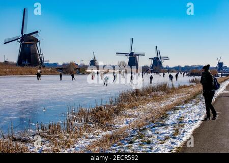 KINDERDIJK, NIEDERLANDE - FEBRUAR 13: Am 13. Februar 2021 wird man in Kinderdijk, Netherla das Winterwetter beim Schlittschuhlaufen auf Natureis beobachten Stockfoto