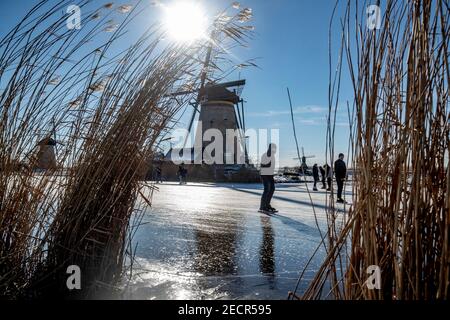 KINDERDIJK, NIEDERLANDE - FEBRUAR 13: Am 13. Februar 2021 wird man in Kinderdijk, Netherla das Winterwetter beim Schlittschuhlaufen auf Natureis beobachten Stockfoto