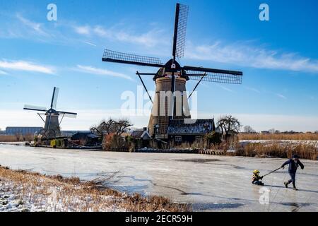 KINDERDIJK, NIEDERLANDE - FEBRUAR 13: Am 13. Februar 2021 wird man in Kinderdijk, Netherla das Winterwetter beim Schlittschuhlaufen auf Natureis beobachten Stockfoto