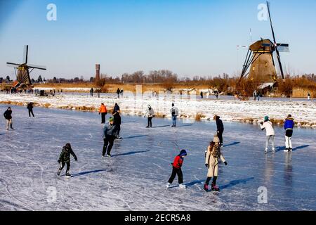 KINDERDIJK, NIEDERLANDE - FEBRUAR 13: Am 13. Februar 2021 wird man in Kinderdijk, Netherla das Winterwetter beim Schlittschuhlaufen auf Natureis beobachten Stockfoto