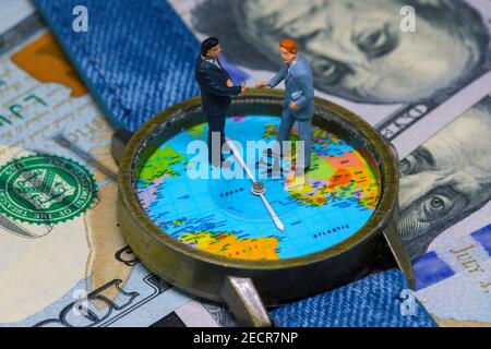 Zwei Geschäftsmänner Figuren auf Zeit und Geld Hintergrund. Weltweites Geschäftskonzept. Internationale Geschäftsvereinbarung. Globales Unternehmen strategische Par Stockfoto