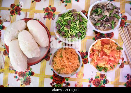 (210214) -- YINCHUAN, 14. Februar 2021 (Xinhua) -- das Foto vom 11. Februar 2021 zeigt das Mittagessen der Familie Zhang einen Tag vor dem chinesischen Neujahrsfest in Yinchuan, der Autonomen Region Ningxia Hui im Nordwesten Chinas. Zhang Junming, 55, lebte einst in der Gemeinde Hongbaiyang, einem wirtschaftlichen Rückstand im südlichen Ningxia. Als er noch jung war, war Zhang bei einem Unfall schwer verletzt worden und litt daher an Beinbehinderungen, die ihn daran hinderten, in den großen Städten nach Arbeitsmöglichkeiten zu suchen. So mussten er und seine Familie aus den armen Erträgen auf dem kargen Ackerland ihren Lebensunterhalt abkratzen. Die Lebensqualität Stockfoto