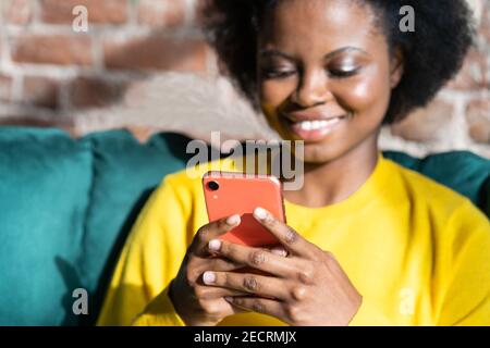 Happy Black Millennial junge Frau mit Handy, Eingabe von Nachricht, in sozialen Netzwerken zu nehmen Stockfoto