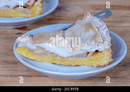 Apfelsahnetorte aus kurzem Gebäck mit Pudding in der heimischen Küche. Stück Apfelkuchen auf dem weißen Teller. Hausgemachtes Backen. Nahaufnahme Stockfoto