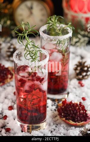 Glas mit Granatapfel Margarita mit kandierten Preiselbeeren, Rosmarin. Perfekter Cocktail für eine Weihnachtsfeier Stockfoto