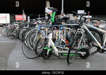 Viele geparkte Fahrräder und ein Elektroroller befinden sich in Zürich, Schweiz, März 2020. Fahrräder sind in großen Städten eine gute Transportart. Stockfoto