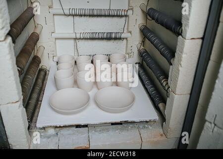 Neu gemacht blank Geschirr auf einer Plattform für eingerichtet Brennofen im Ofen Stockfoto