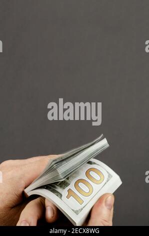 Verschwommen, Bewegungsunschärfe, Weichzeichner. Die Finger eines Mannes zählen das Geld. Nahaufnahme der Hände mit einem Stapel von $100 Scheinen. Speicherplatz kopieren Stockfoto