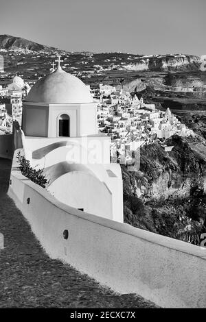 Kleiner griechischer Kirch in Fira Stadt an der Bergküste der Insel Santorini in Griechenland. Schwarzweiß-Fotografie, Landschaft Stockfoto