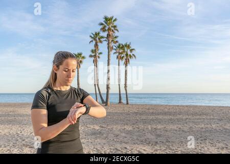 Junge Frau mit Smart Watch vor dem Sport Training im Freien nächsten An die Küste .Fitness aktiv Lifestyle Konzept mit Kopierraum Stockfoto