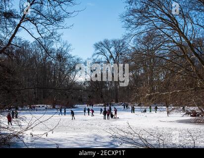 Schlittschuhlaufen in Wintersonne auf gefrorenem See im Tiergarten park in Berlin Stockfoto