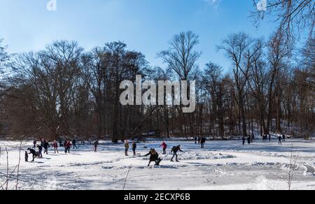 Schlittschuhlaufen in Wintersonne auf gefrorenem See im Tiergarten park in Berlin Stockfoto