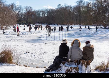 Schlittschuhlaufen in Wintersonne auf gefrorenem See im Tiergarten park in Berlin Stockfoto