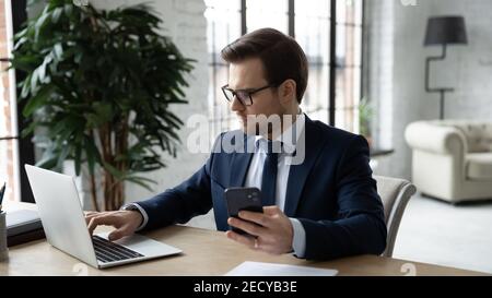 Serious Geschäftsmann verwenden moderne elektronische Geräte im Büro Stockfoto