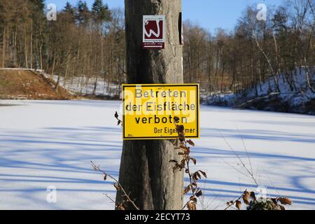 Viersen, Deutschland - Februar 9. 2021): Blick auf gelbes deutsches Schild betreten Sie kein Eisschild mit gefrorenem See-Hintergrund Stockfoto