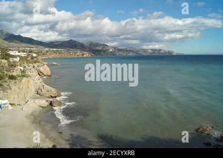 Szenische Aufnahme der Küste von Nerja mit Palmen, Bergen, blauem Himmel und Meer Stockfoto