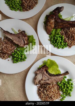 Gebratenes Fleisch auf dem Knochen mit Buchweizenbrei Stockfoto