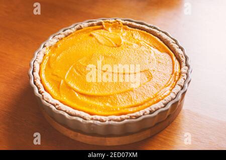 Kürbiskuchen, Orangenkuchen in einer Auflaufform auf einem Holztisch Stockfoto