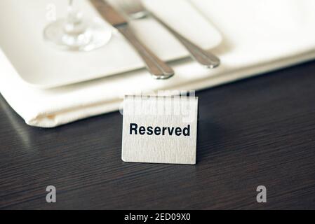 Reserviertes Schild, Eisenplatte auf dem Tisch im Café oder Restaurant, getöntes Bild Stockfoto