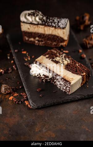 Ein Stück köstlicher Kuchen auf schwarzem Schiefer auf Grungy serviert Hintergrund Stockfoto