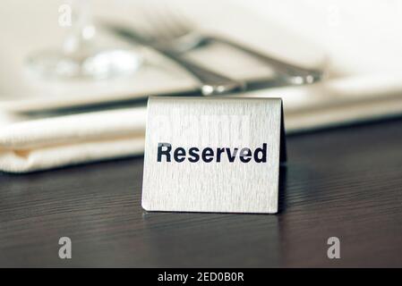 Reserviertes Schild, Eisenplatte auf dem Tisch im Café oder Restaurant, getöntes Bild Stockfoto