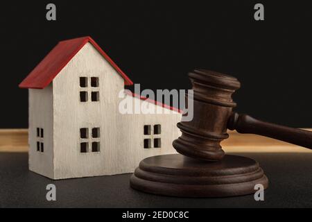 Richter Hammer und Modell des Hauses. Beschlagnahmtes Gehäuse. Lösen von Eigentumsstreitigkeiten Stockfoto