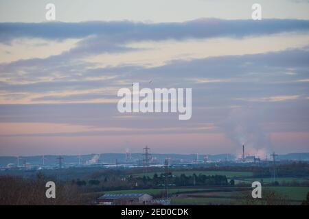 Blick über die Landschaft zum industriellen Avonmouth und dem Seabank Kraftwerk, das Dampf abpumpt, über Windturbinen und Strommasten Stockfoto