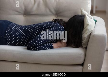 Millennial Frau begraben Kopf in Kissen gehen durch emotionale Krise Stockfoto