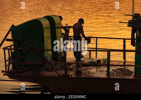 Monywa, Myanmar - 22. Dezember 2019: Blick auf einen Mann, der auf seinem Boot duscht, bevor er nach Hause geht Stockfoto