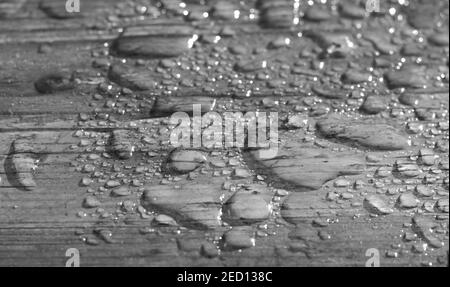 Nahaufnahme der Holzoberfläche in Wassertropfen. Nasse Holzstruktur. Wasser tropft auf einem Rustis Holzbrett. Leerer Platz für Text oder kreatives Design. Stockfoto