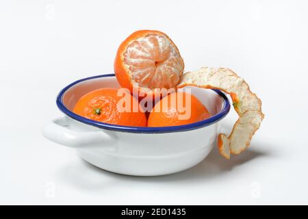 Clementinen in einer Schale, ungeschält und halb geschält, weißer Hintergrund, Deutschland Stockfoto